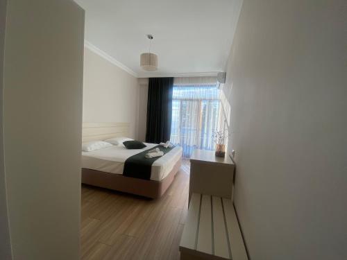a bedroom with a bed and a window at Queen Tamar in Batumi