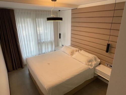 a bedroom with a white bed and a window at Luxury boutique playa Silgar in Sanxenxo
