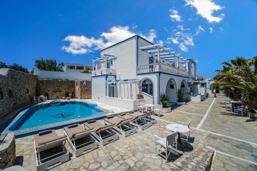 a villa with a swimming pool and chairs at Stavros Villas in Karterados