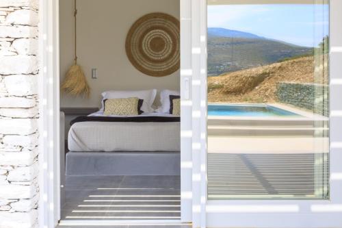 a bedroom with a view of a pool through a door at Iliades Luxury Boutique Suites in Batsi