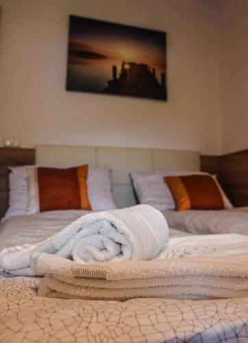 two beds with towels sitting on top of them at Hiša Bohinc z wellnessom in Tolmin