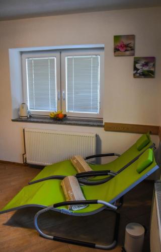 a room with a green treadmill in front of a window at Hiša Bohinc z wellnessom in Tolmin