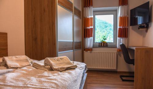 a room with a bed with two towels on it at Hiša Bohinc z wellnessom in Tolmin