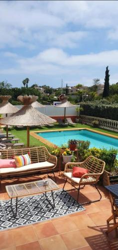 a swimming pool with two chairs and an umbrella at Hôtel Athéna in Agde