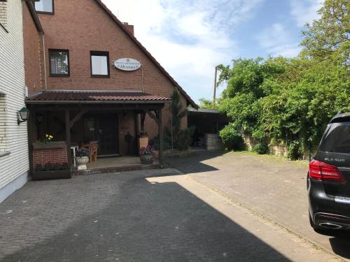 a car parked in front of a brick house at Hotel Hennies Hannover Sehnde in Hannover