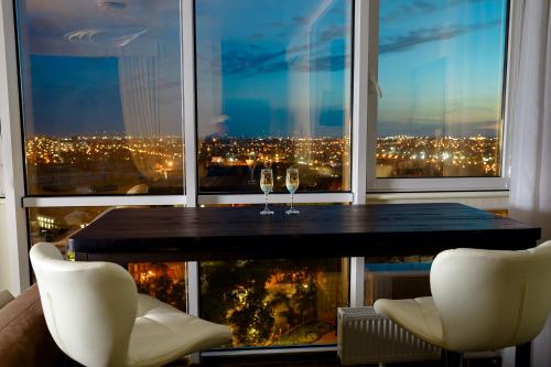 a table with two wine glasses in front of a window at Апартаменты в Одессе in Odesa