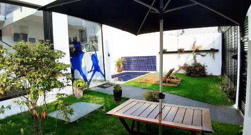 a patio with a wooden bench and an umbrella at Blue Ocean Suites - Aeroporto Congonhas in Sao Paulo
