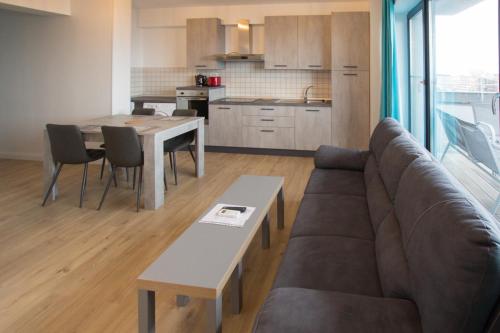 a living room with a couch and a table and a kitchen at Lake Boutique Apartments & Rooms in Mamaia