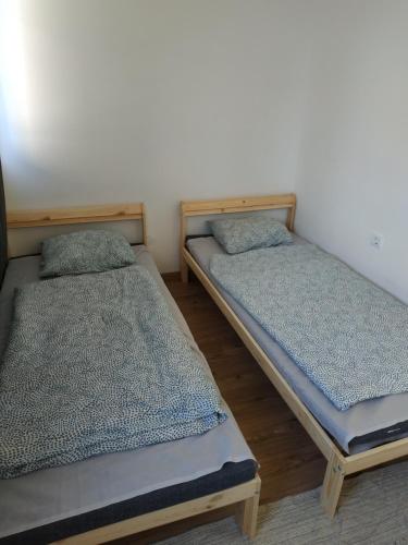 two twin beds in a room withthritisthritisthritisthritisthritisthritisbestosbestosbestos at Vivienne Apartment in Zamárdi