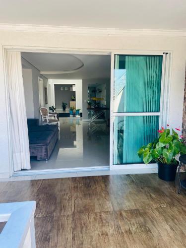 a living room with a large sliding glass door at CWB 997 com piscina aquecida jacuzzi e Playground in Curitiba