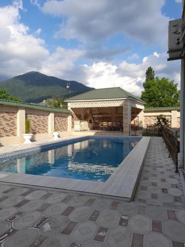 a swimming pool in a yard with a house at Raffles Villa with pool in Gabala