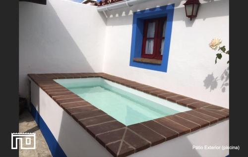 a swimming pool in the corner of a house at Casinha de Montoito in Montoito