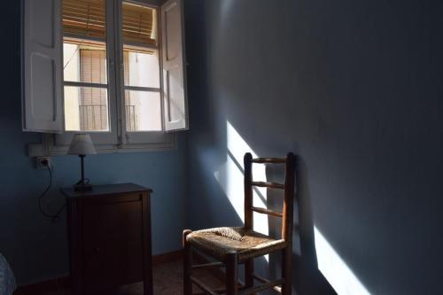 une chambre bleue avec une chaise et une fenêtre dans l'établissement Casa del Bueno, à Peralta de la Sal