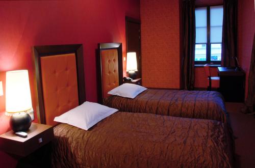 two beds in a hotel room with red walls at Vanilla Hotel in Lublin