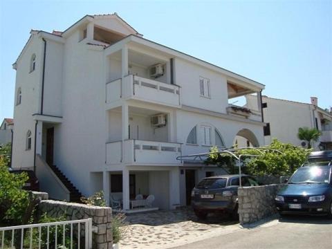 a white building with a car parked in front of it at Apartment in Punat with Terrace, Air conditioning, Wi-Fi, Washing machine (3829-2) in Punat
