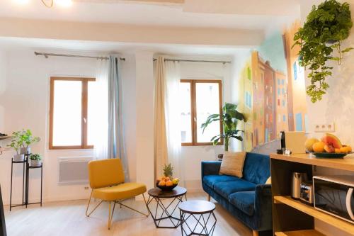 un salon avec un canapé bleu et un fauteuil jaune dans l'établissement App-ART Coeur du Panier Vieux-Port Vieille Charité, à Marseille