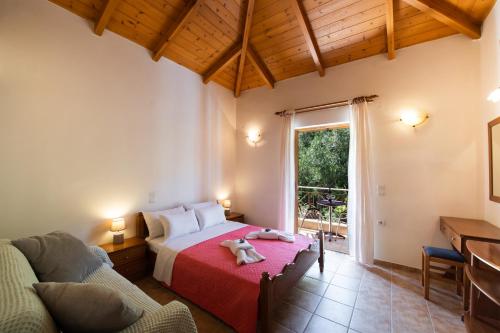 a bedroom with a bed and a couch and a window at Delphinus Villa Nefeli in Agios Nikitas