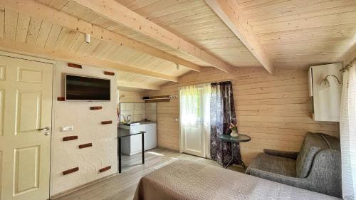 a small room with a couch and a television in a room at Guest House Rannaliiv in Võsu