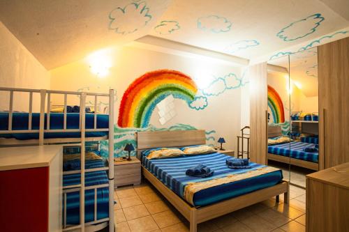 a bedroom with a rainbow mural on the wall at Arcobaleno 2 in Villasimius