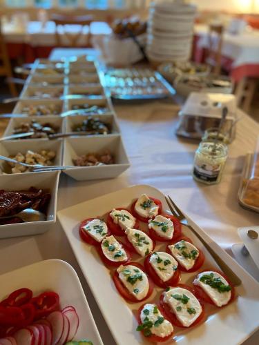 a table topped with tomatoes and other appetizers at Pension Schmidt in Podersdorf am See