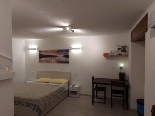 a small bedroom with a bed and a table at Maison De Marie in Donnas