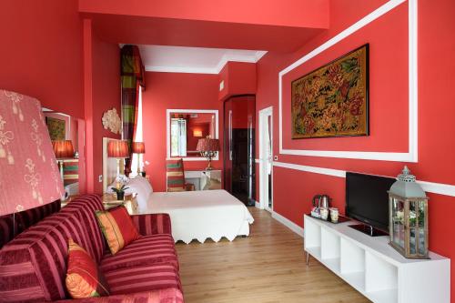 a red room with a bed and a couch at Adua & Regina di Saba Wellness & Beauty in Montecatini Terme