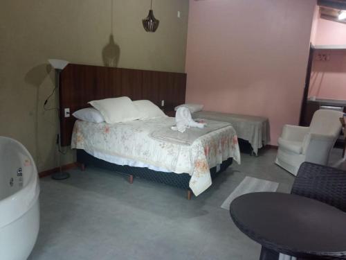 a bedroom with a bed and a bath tub at Recanto Berço das Aguas in Piraquara