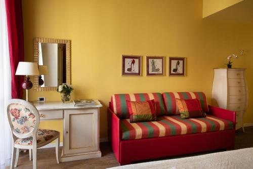 a living room with a red couch and a table at Adua & Regina di Saba Wellness & Beauty in Montecatini Terme