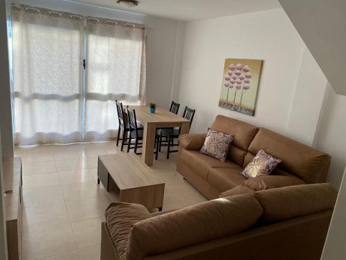 a living room with a couch and a table at Nice rooms in a shared apartment in the centre of Corralejo in Corralejo