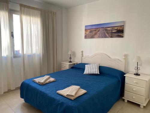 a bedroom with a blue bed with two towels on it at Nice rooms in a shared apartment in the centre of Corralejo in Corralejo