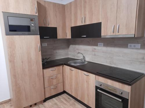 Una pequeña cocina con fregadero y microondas. en 10 PERCENT OFF UNTIL 30TH OF NOVEMBER - Apartment Artistika, Paid parking off-site, Mandatory Reservation, en Belgrado