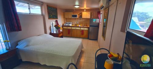 
a bedroom with a bed and a refrigerator at A1 Apartments Aruba in Oranjestad
