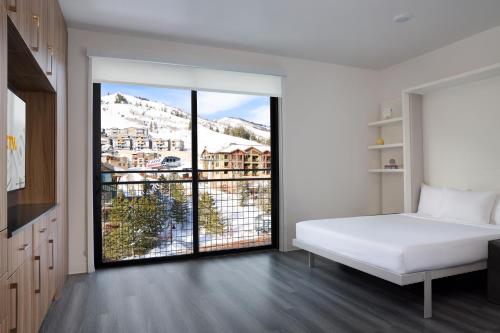 a bedroom with a white bed and a large window at Canyon Haus in Park City
