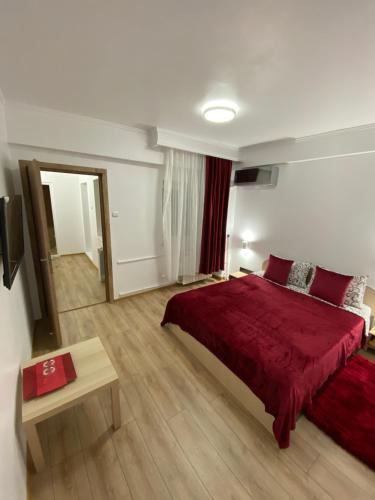 a bedroom with a red bed and a table at Oriana in Constanţa