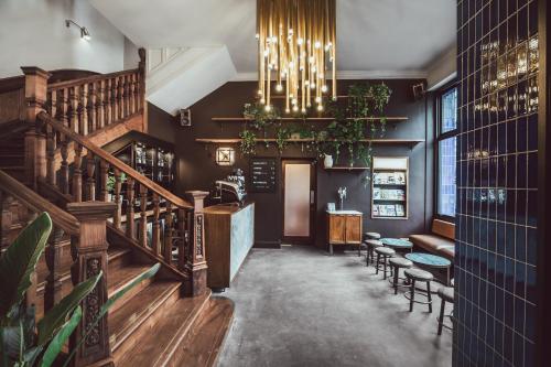 a restaurant with a staircase and tables and chairs at The Pilgrm in London