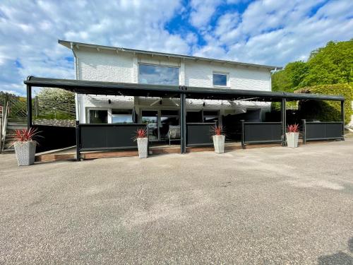 une grande maison blanche avec un garage noir dans l'établissement Vid Gekås Ullared Boende B&B, à Ullared