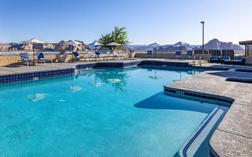 a large swimming pool with blue water and chairs at Lake Powell Resort in Page