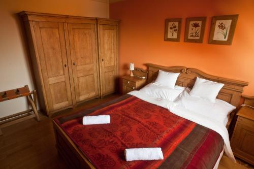 a bedroom with a large bed with white pillows at St.Michael Panzió Lovaspark in Vasszentmihály