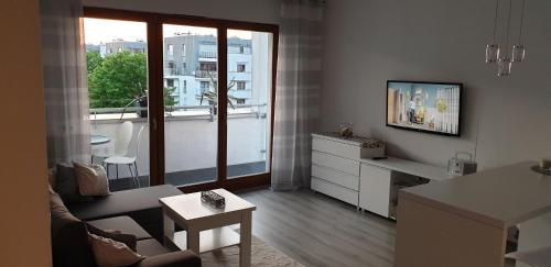 Televízia a/alebo spoločenská miestnosť v ubytovaní Apartament Reda