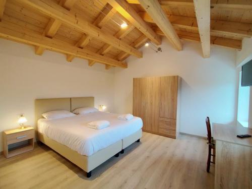 ein Schlafzimmer mit einem Bett und einer Holzdecke in der Unterkunft Antico Melo B&B in Vignole