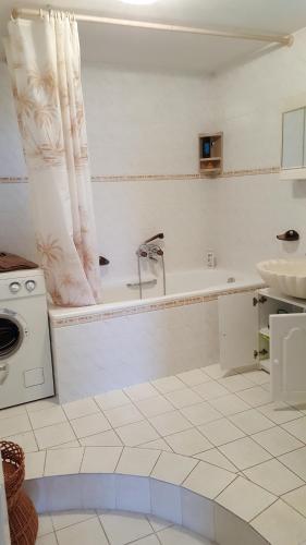 ein weißes Badezimmer mit einer Badewanne und einem Waschbecken in der Unterkunft Eger Napsugar in Eger