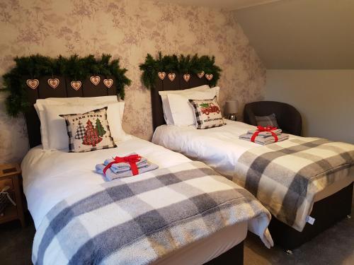 two beds in a room with christmas decorations on them at Smithy Cottage in Kirkmichael