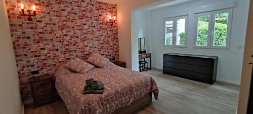 Un dormitorio con una cama y una pared de ladrillo. en El Parque Suite, en Benalmádena