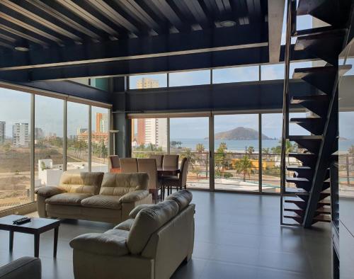 a living room with couches and a spiral staircase at Manzara Resort in Mazatlán
