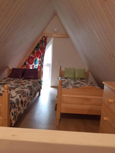 a bedroom with two beds in a attic at Kotedžas poilsiui in Palanga