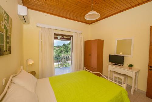 a bedroom with a green bed and a window at Nicoles Houses Arillas Corfu in Arillas