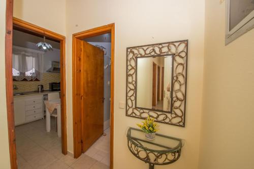 a mirror hanging on a wall in a bathroom at Nicoles Houses Arillas Corfu in Arillas