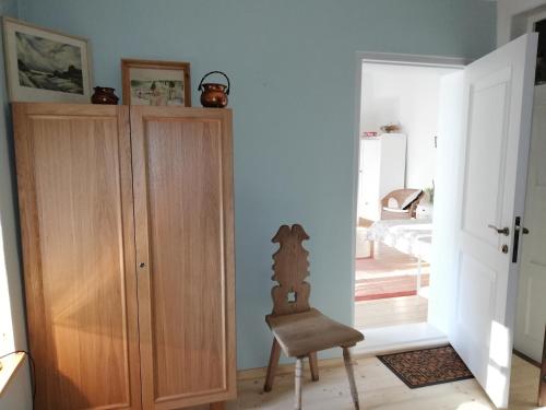 a room with a wooden cabinet and a chair at Pālena apartamenti in Tērvete
