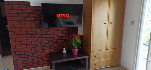 a living room with a brick wall and a tv at Studio near the port !!! in Paralia Katerinis