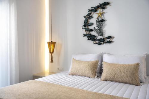 a white bed with pillows and a wreath on the wall at Vinas Place City Center in Fira